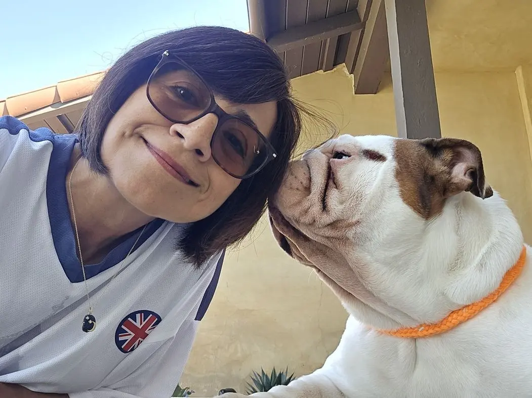 Angelica cheek to cheek with a white English Bulldog